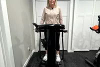 A person stands on the Lifepro Rhythm Vibration Plate
