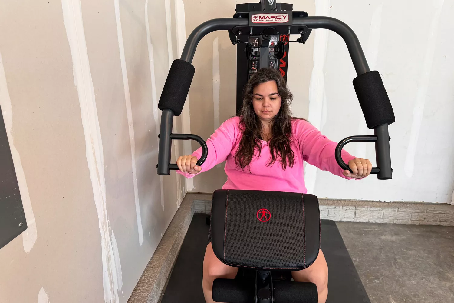 A person exercises using the Marcy MWM-989 150 lb Stack Weight Home Gym