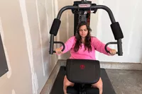 A person exercises using the Marcy MWM-989 150 lb Stack Weight Home Gym