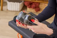 A person pressing a button on the RENPHO Power Massage Gun