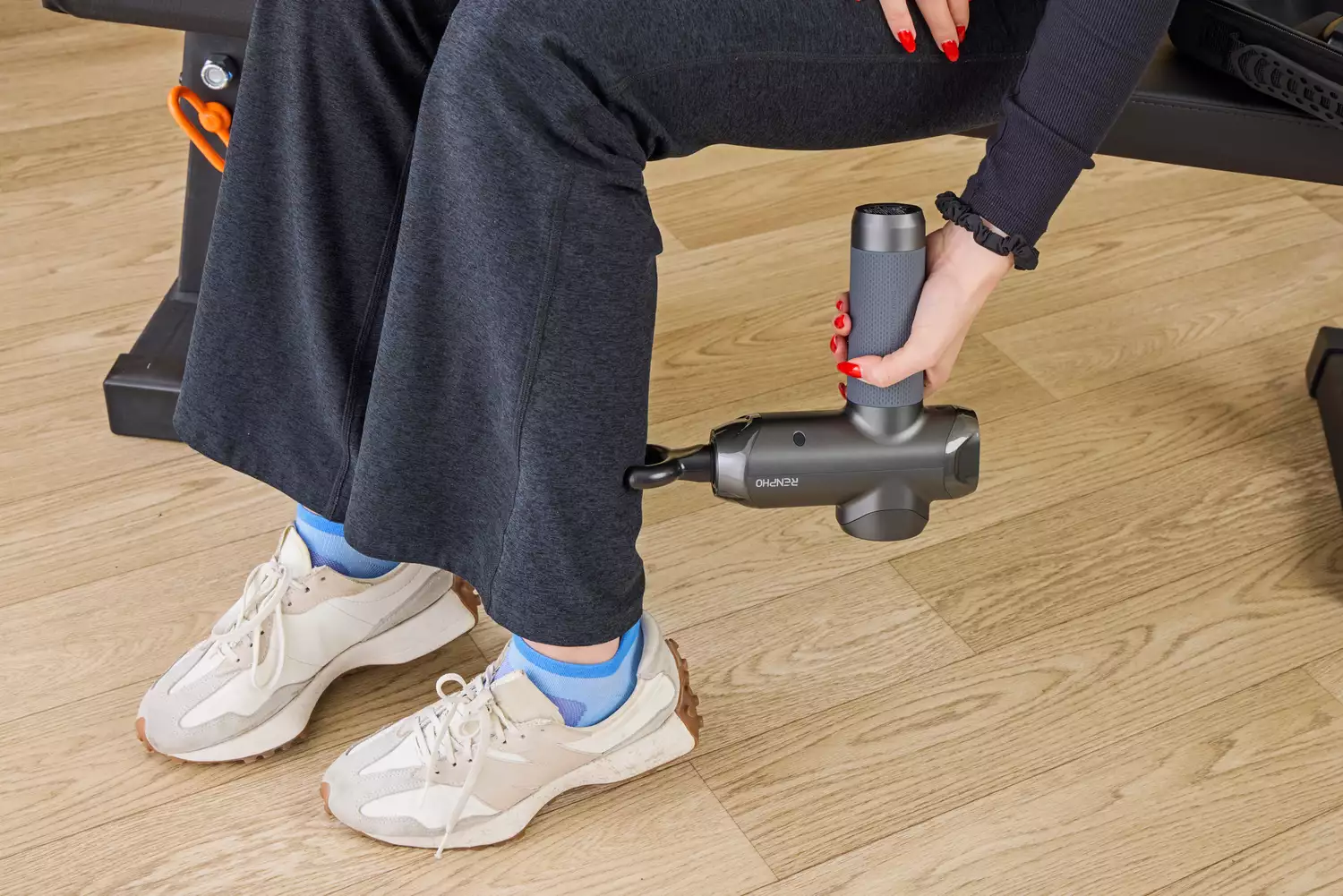 A person using the RENPHO Power Massage Gun on their calf 