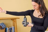 A person using the RENPHO Power Massage Gun on their arm