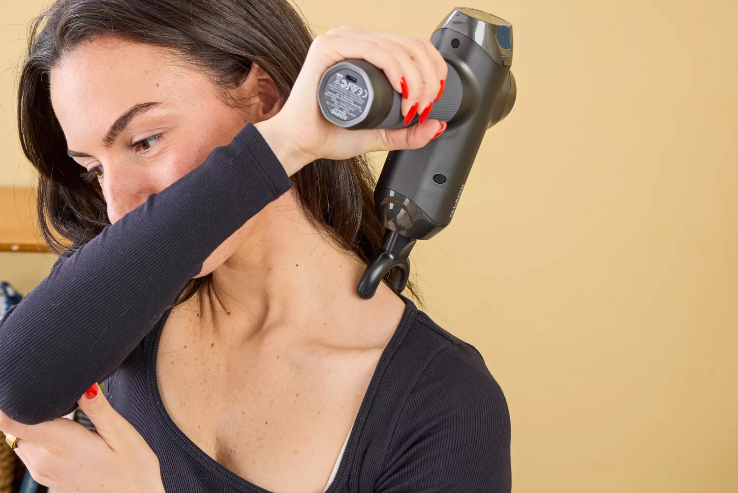 A person using the RENPHO Power Massage Gun on their shoulder