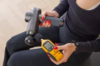 A person holding a tool to the RENPHO Power Massage Gun