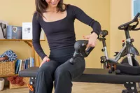 A person using the Theragun Prime on their thigh