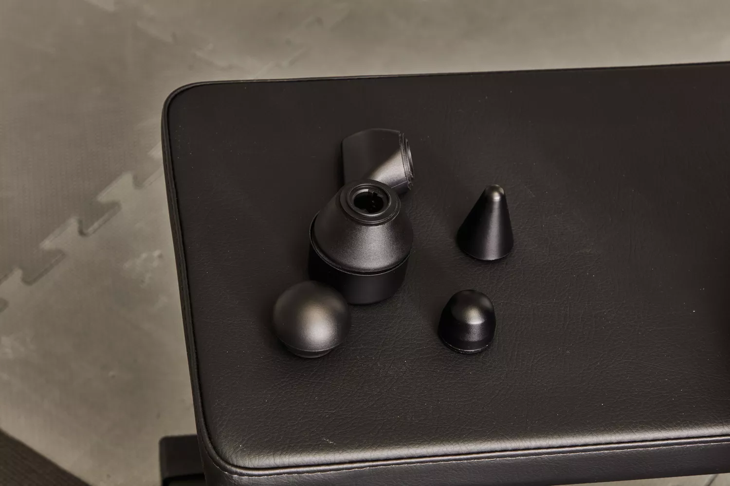 Therabody Theragun Prime (4th Generation) attachments on a weight bench