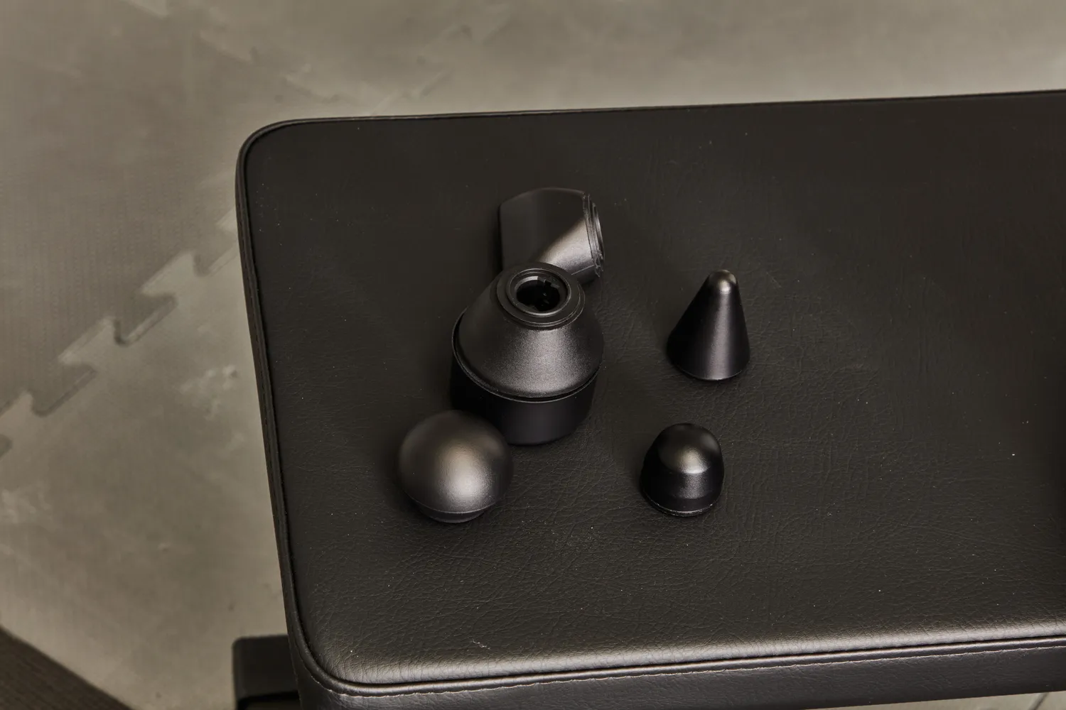 Therabody Theragun Prime (4th Generation) attachments on a weight bench