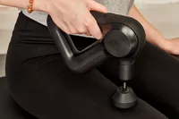 Person using Therabody Theragun Prime (4th Generation) on thigh muscle