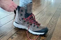 A person laces up the Danner Arctic 600 Side-Zip Boot