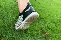 Person lifting foot while wearing Doussprt Men’s Quick Drying Water Shoes on grass