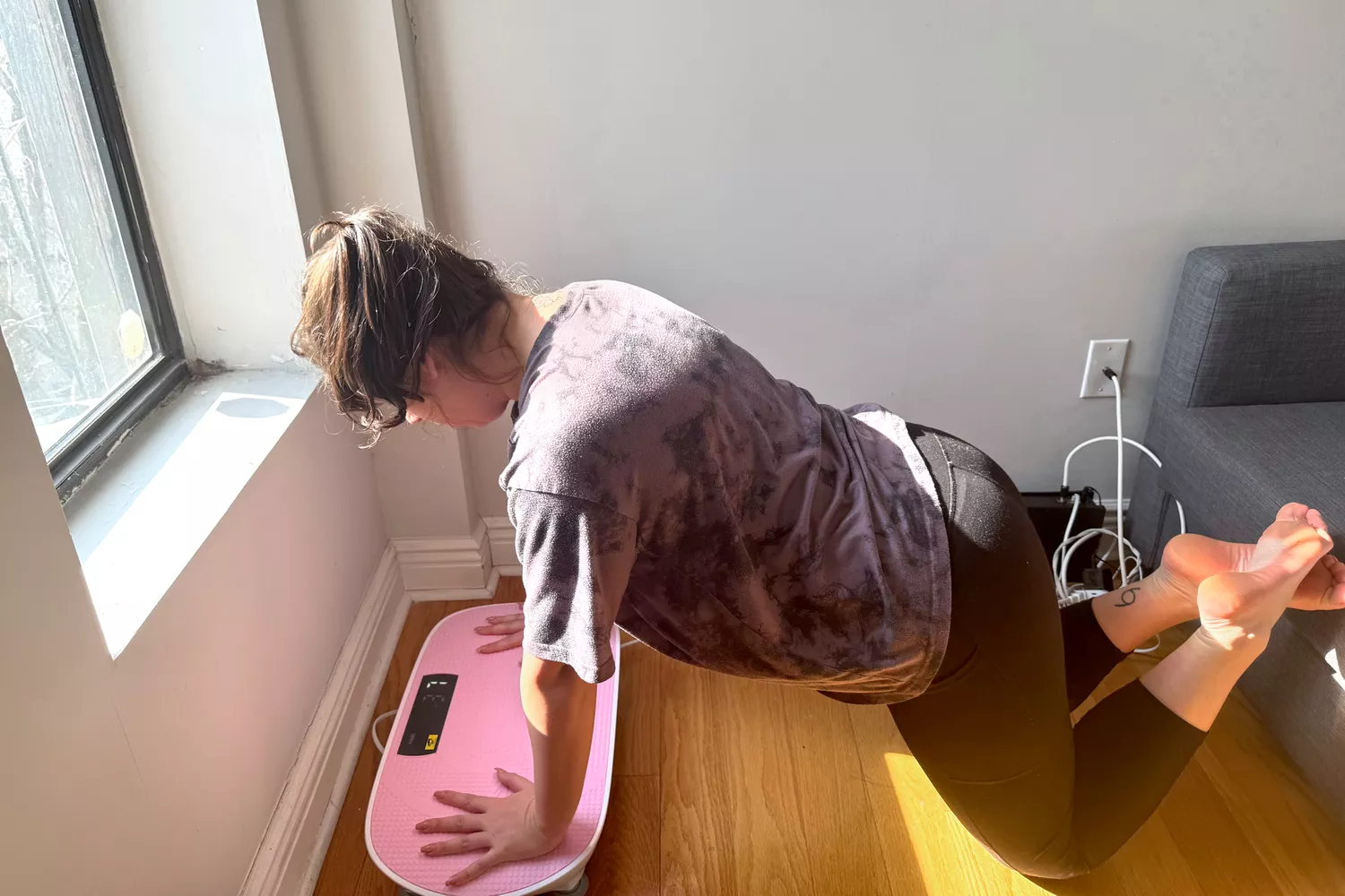 A person does pushups on the Merach Whole Body Vibration Plate