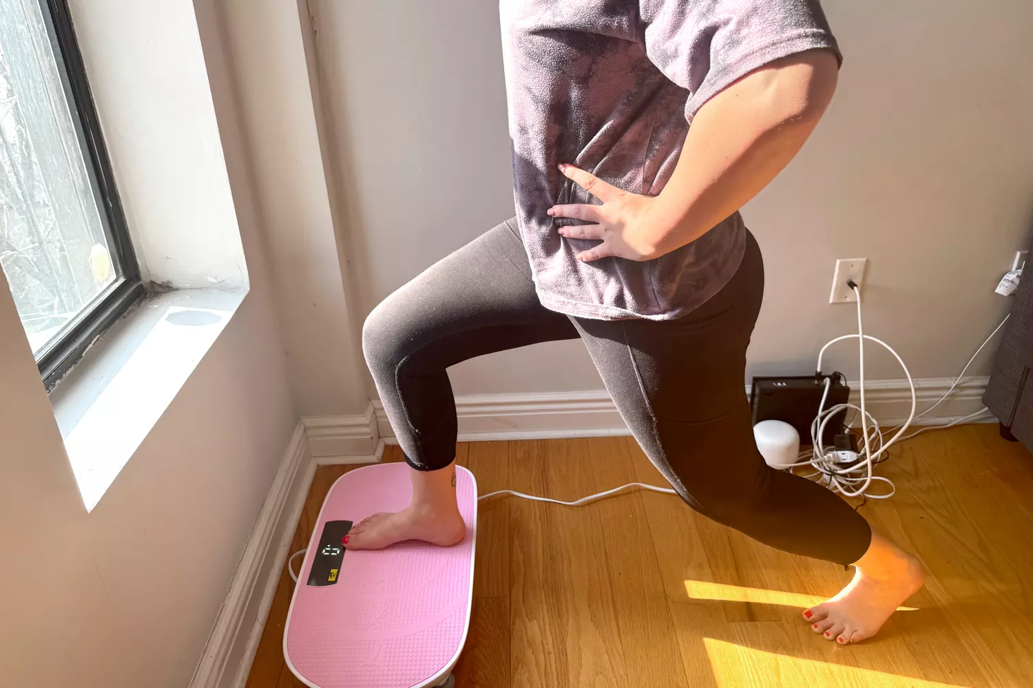 A person does a lunge on the Merach Whole Body Vibration Plate