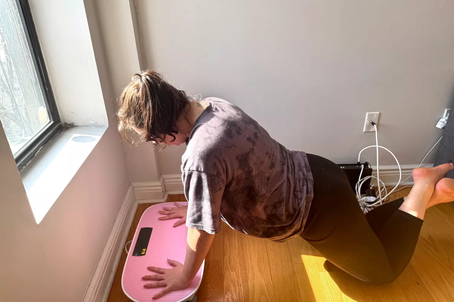 A person does pushups on the Merach Whole Body Vibration Plate