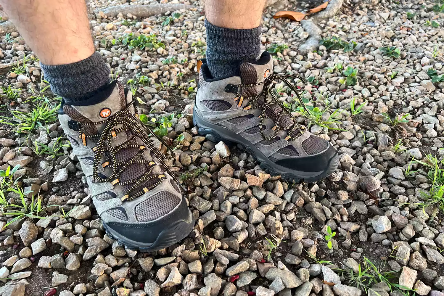 Feet wearing Merrell Men's Moab 3 Mid Hiking Boot standing on stone