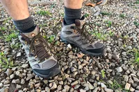 Feet wearing Merrell Men's Moab 3 Mid Hiking Boot standing on stone