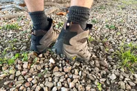 Person stepping on rocks wearing Merrell Moab 3 Mid Waterproof Hiking Boots
