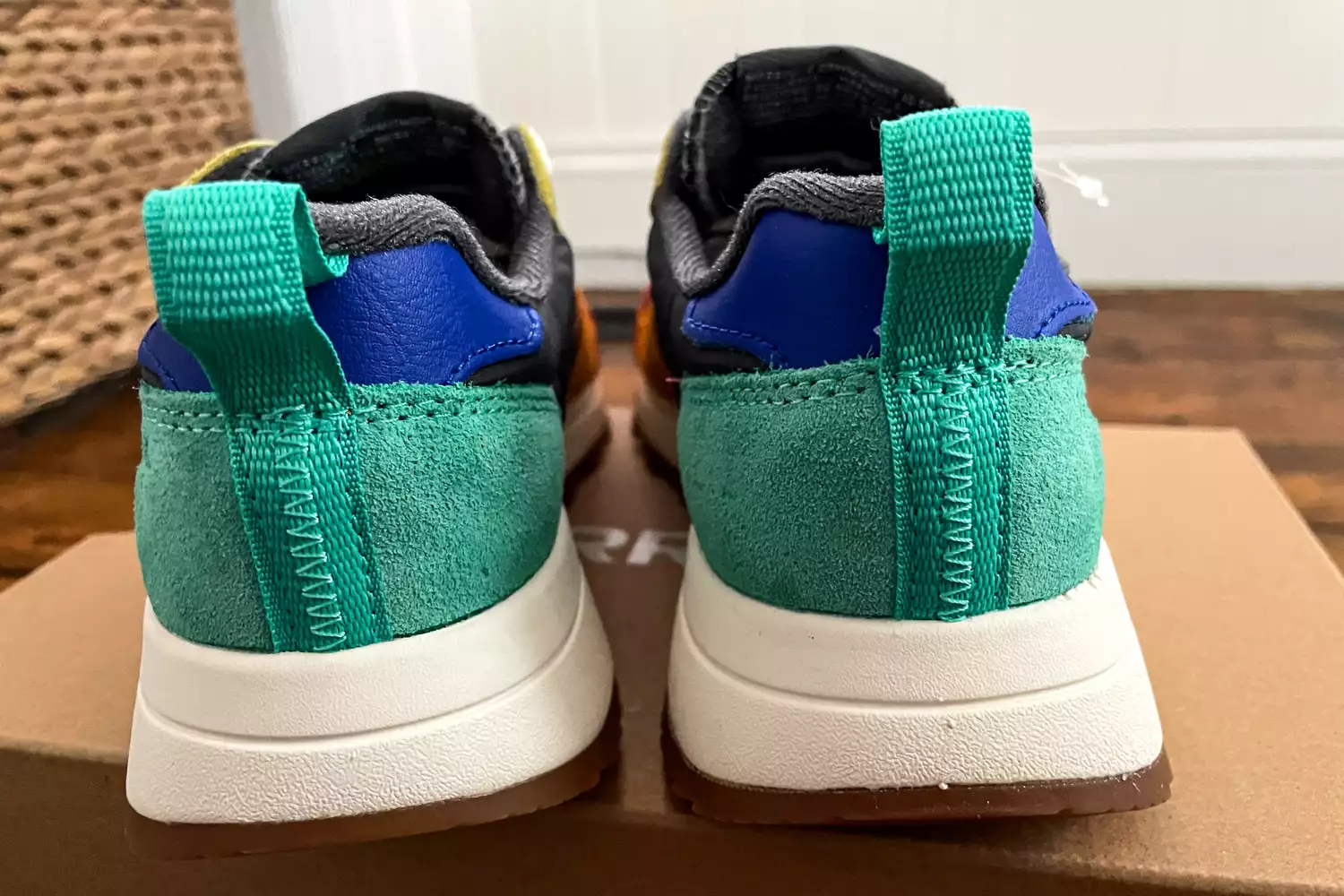 The back of the Merrell Women's Alpine 83 Sneaker Sport sneakers placed on top of their box