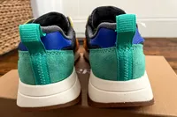 The back of the Merrell Women's Alpine 83 Sneaker Sport sneakers placed on top of their box