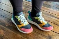 A close-up of the Merrell Women's Alpine 83 Sneaker Sport sneakers worn on a wooden floor