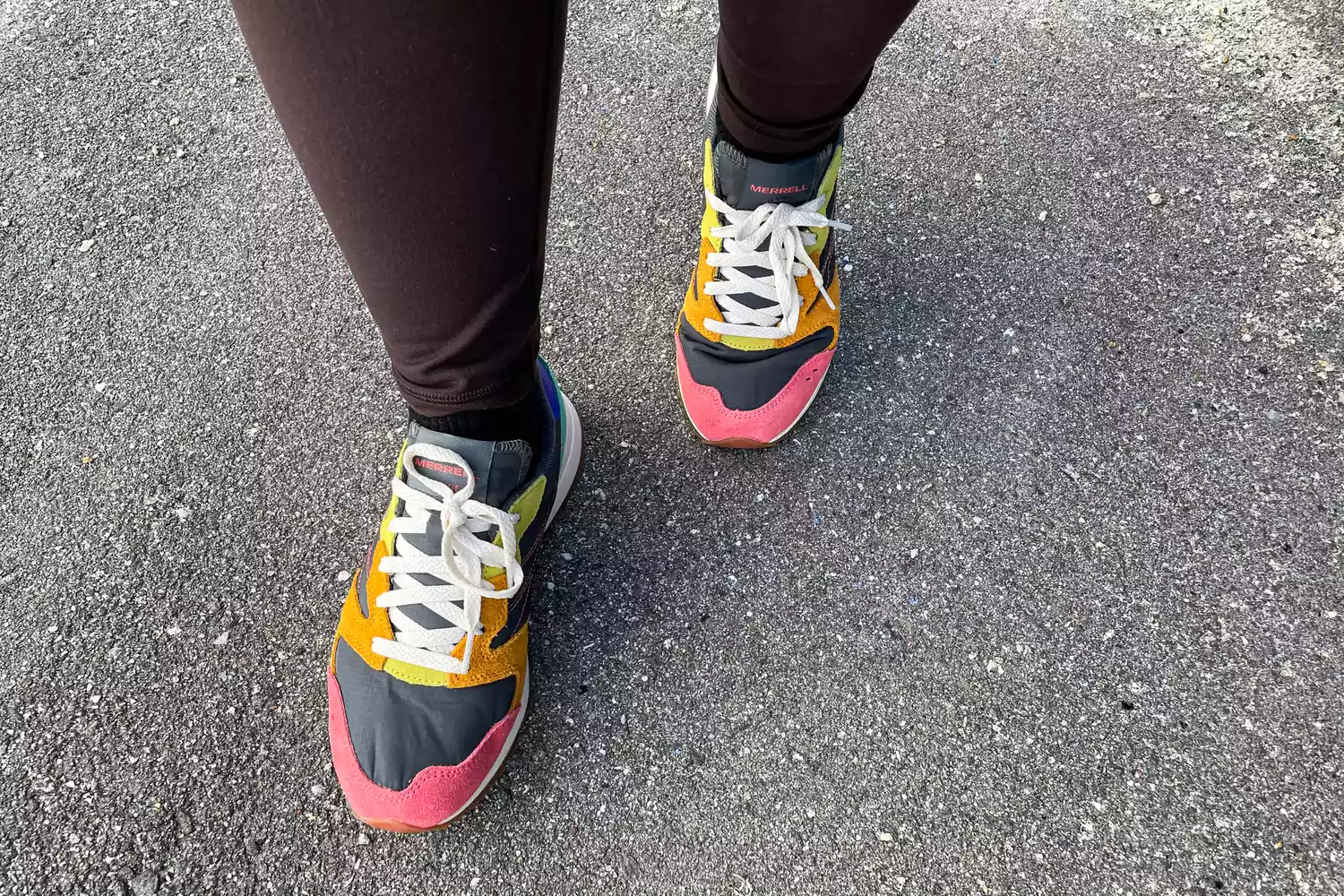 An overhead view of a legs walking on a road while wearing the Merrell Women's Alpine 83 Sneaker Sport