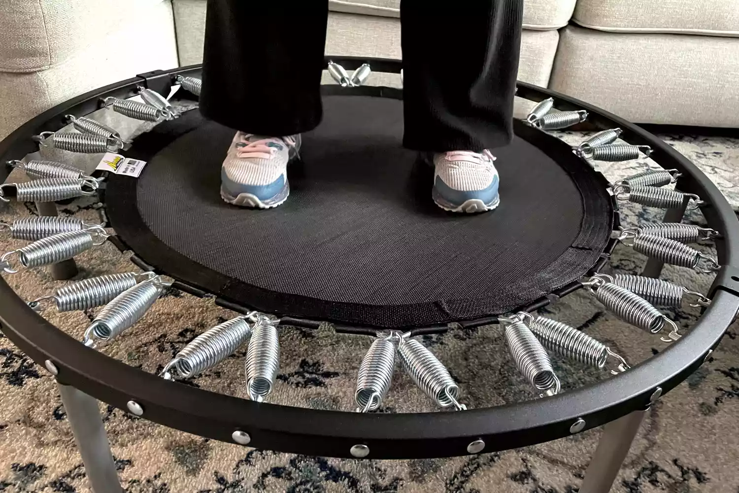 A person stands on the Needak Soft-Bounce Folding Rebounder