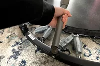 A person folds the leg of the Needak Soft-Bounce Folding Rebounder toward the mat