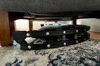 The Needak Soft-Bounce Folding Rebounder folded and placed under a chair for storage