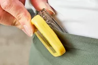 A person clips the NESKLA 3D Pedometer with Large Digital Display to their waistband