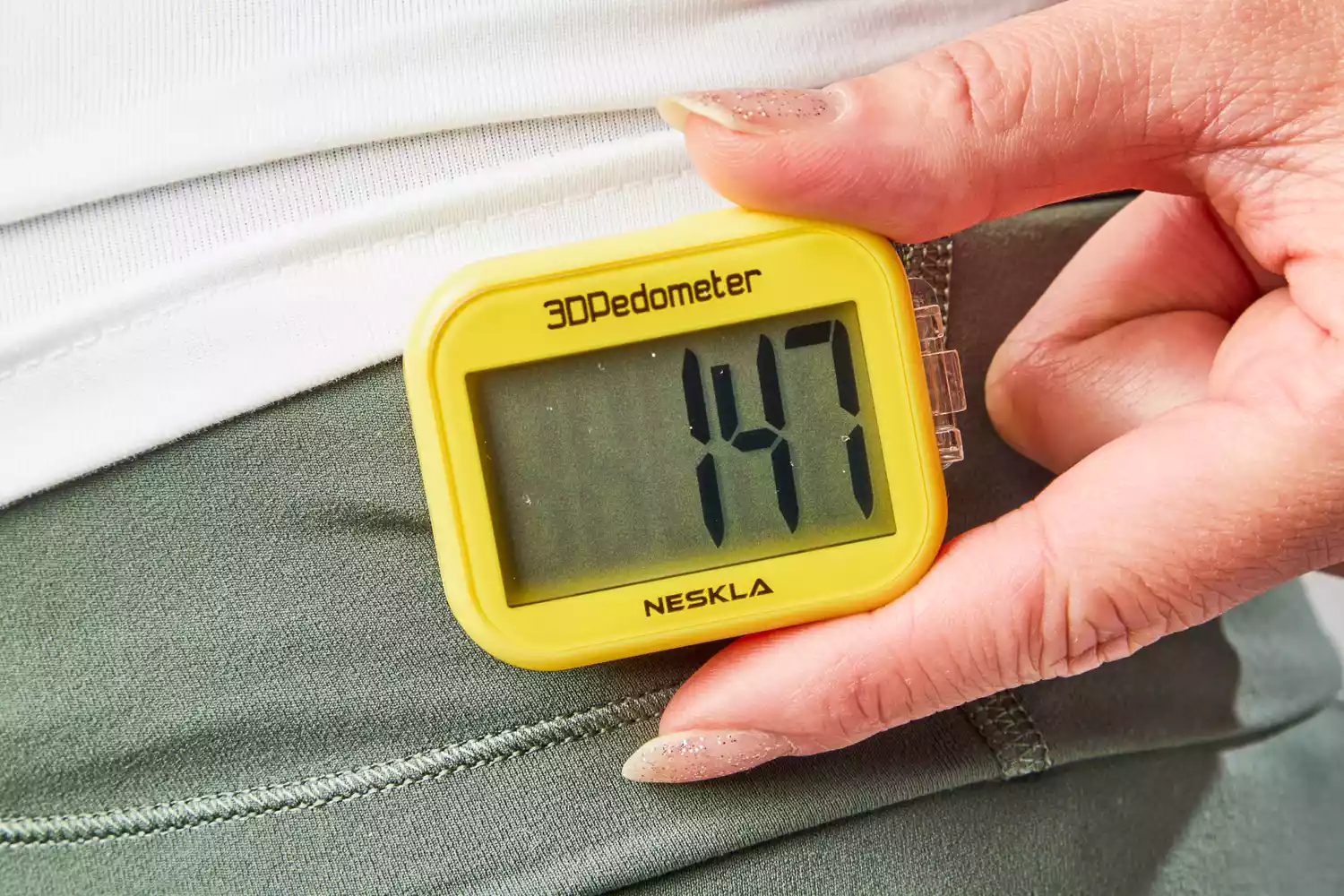 A person adjusts the NESKLA 3D Pedometer with Large Digital Display