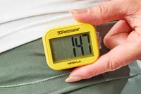 A person adjusts the NESKLA 3D Pedometer with Large Digital Display