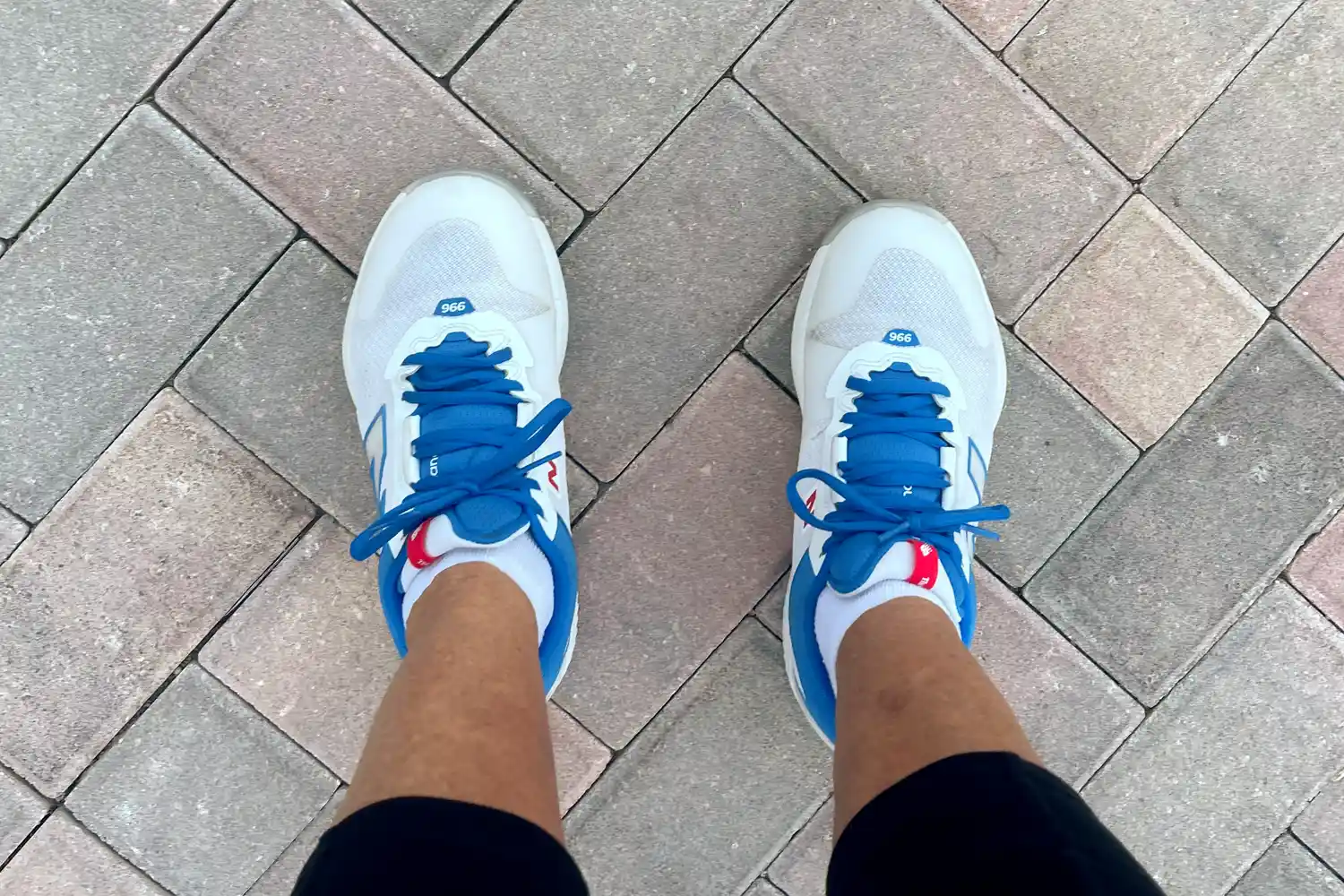 An overhead view of a person wearing the New Balance Women's FuelCell 996v6 Pickleball Shoes on brick
