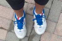 A person wears the New Balance Women's FuelCell 996v6 Pickleball Shoes on brick