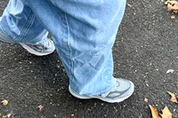 A person walks outside while wearing the New Balance Women's Made in USA 990v6 Sneakers