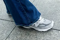A person walks outside while wearing the New Balance Women's Made in USA 990v6 Sneakers