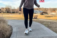 A person walking on a sidewalk while wearing the New Balance Women's Fresh Foam Arishi v4
