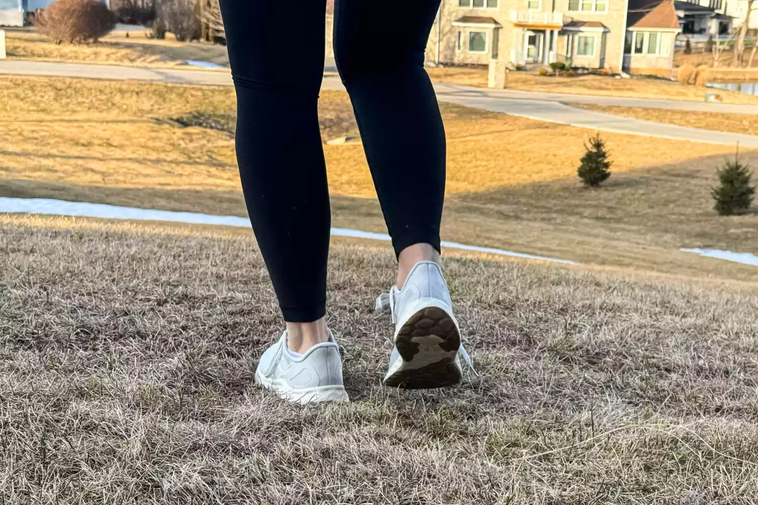 A person's legs from the back whilw they wear the New Balance Women's Fresh Foam Arishi v4 in grass