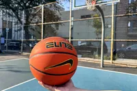A person holds the Nike Elite Championship Basketball