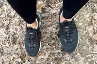 A person wears the Nike Motiva Women's Walking Shoes while walking outside
