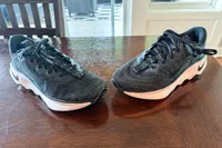 A pair of Nike Motiva Women's Walking Shoes on a wooden table