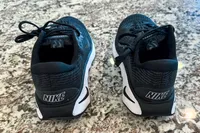 The brand name printed on the back of the Nike Motiva Women's Walking Shoes