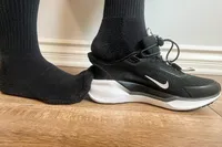 A person slips their foot out of the Nike Pegasus EasyOn Women's Road Running Shoes