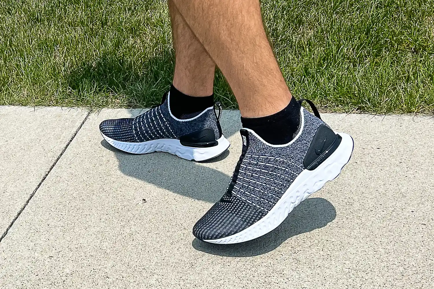 A person walks outside while wearing the Nike React Phantom Run 2 Men's Road Running Shoes
