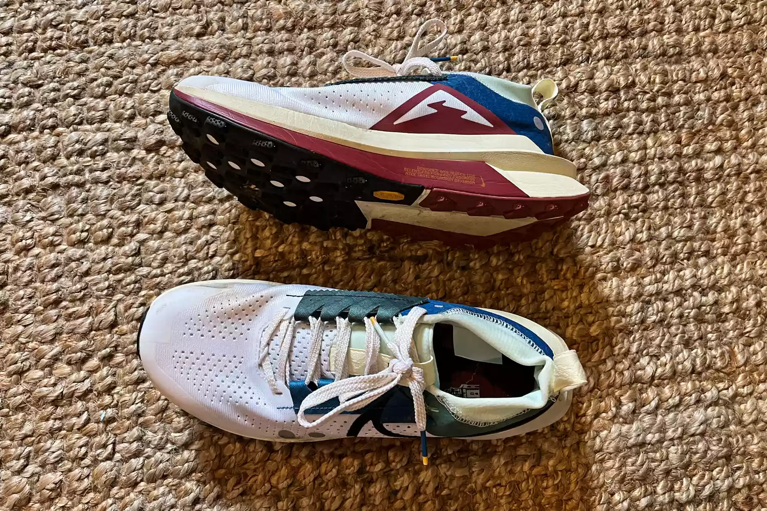 A pair of Nike Zegama 2 Women's Trail Running Shoes on a jute rug