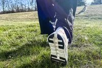 A person walks outside while wearing the On Men's Cloudtilt Walking Shoes