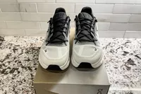 A front view of a pair of On Men's Cloudtilt Walking Shoes on a shoebox