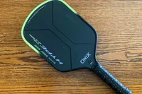 The Onix Hype X Pro Raw Carbon Pickleball Paddle on a wooden table