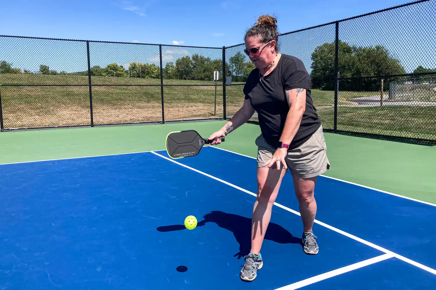 A person hits a pickleball with the Onix Hype X Pro Raw Carbon Pickleball Paddle