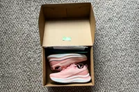 A pair of Orthofeet Women's Relay Sneakers in a cardboard box on a carpeted floor