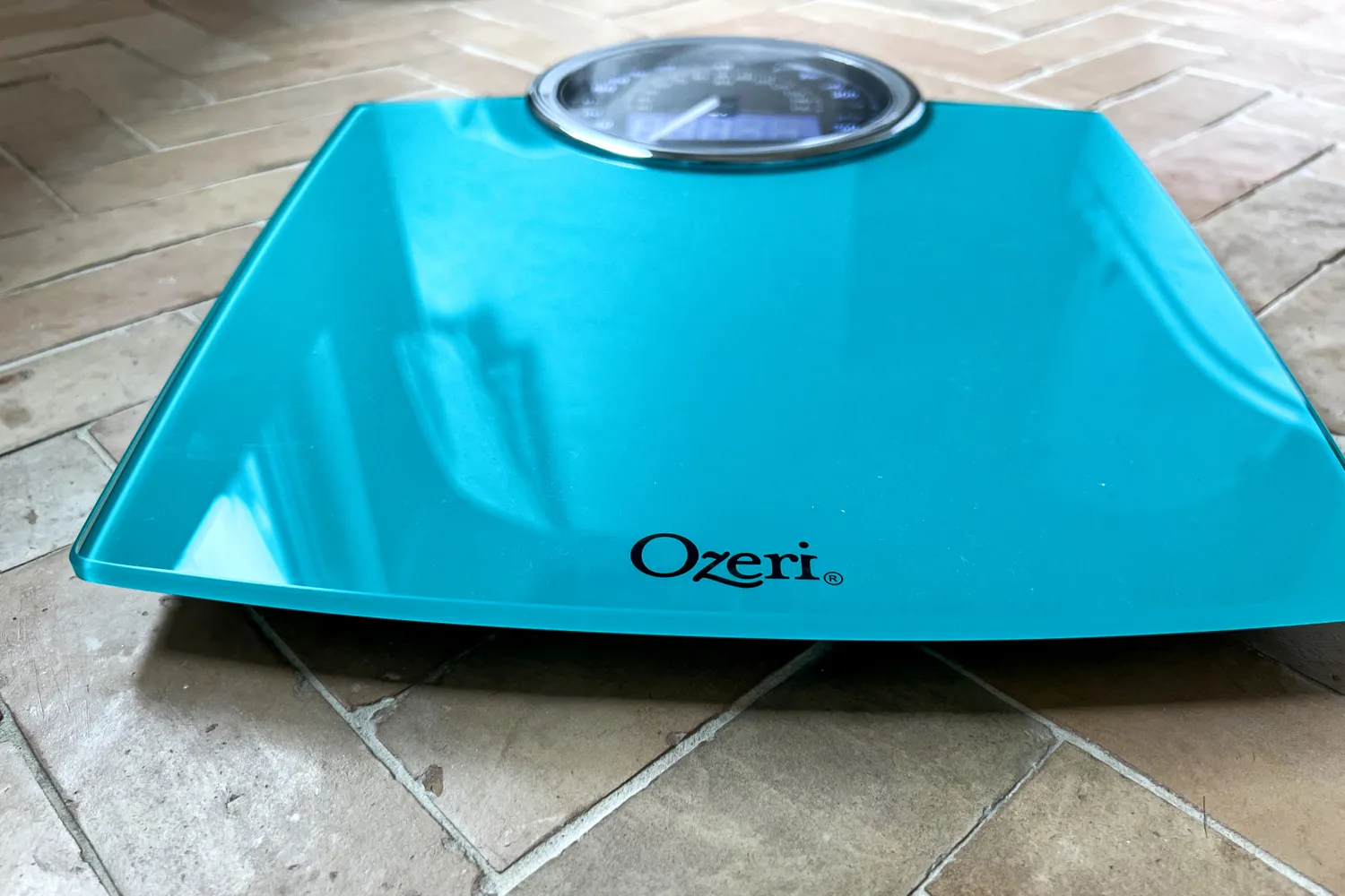 The Ozeri Rev 400 lbs Bathroom Scale on a tile floor