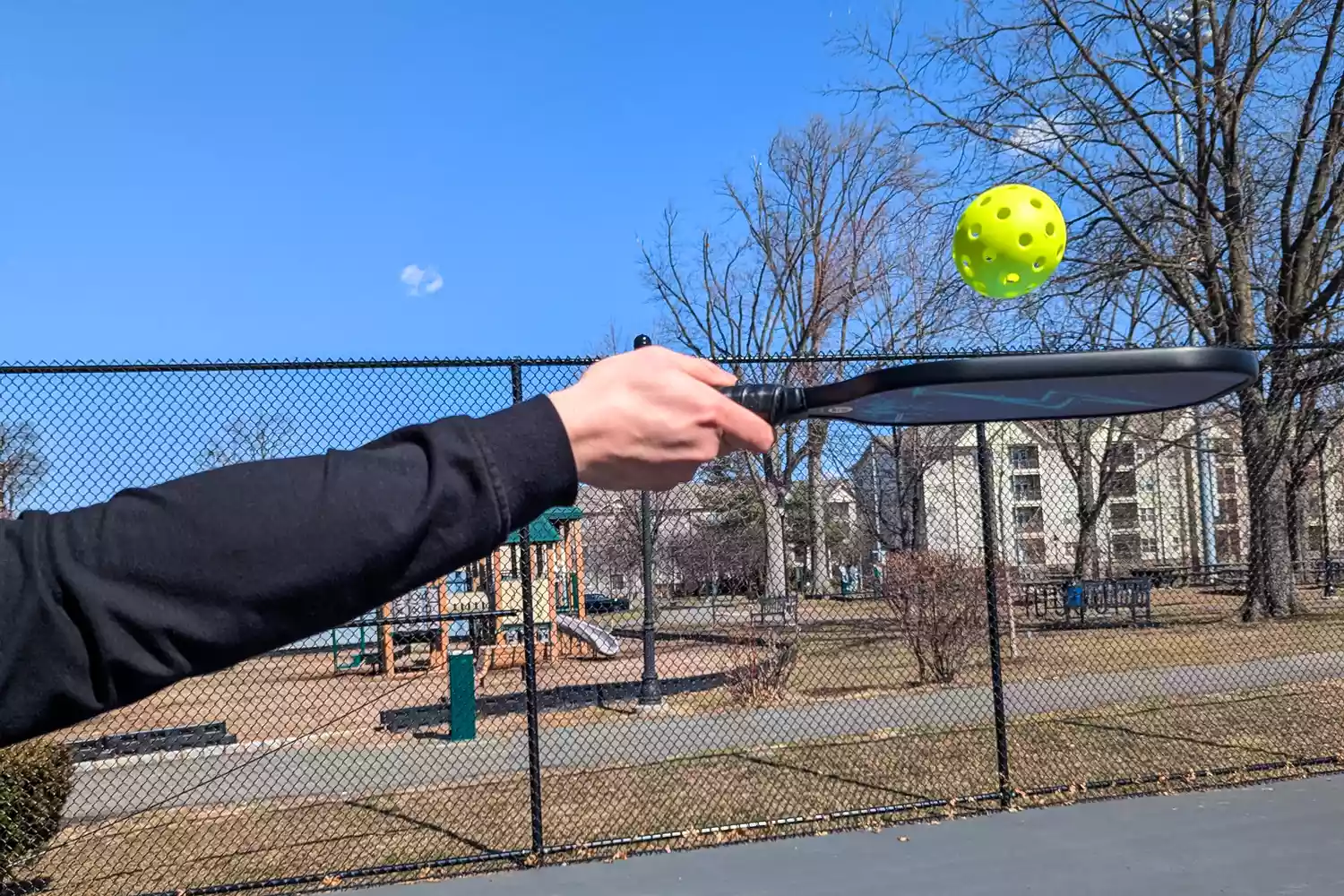 A person using the Panel Sound Pickleball Paddles Set of 2 to hit a ball